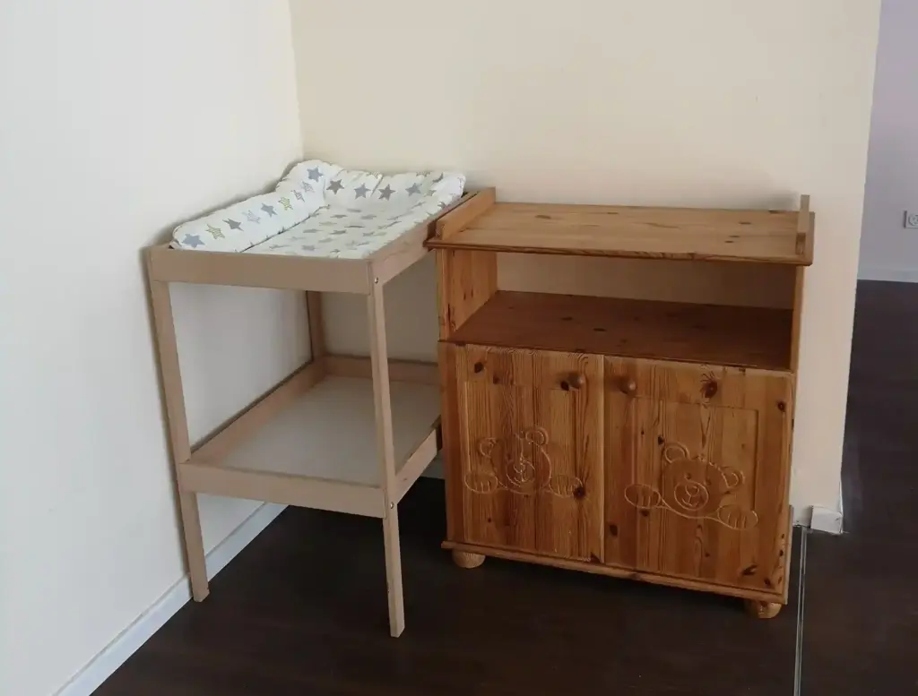 Zu sehen sind ein Wickeltisch neben einer Kommode mit Bärchenmotiv.